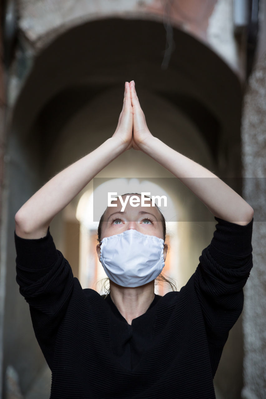 Close-up of woman wearing flu mask meditating outdoors