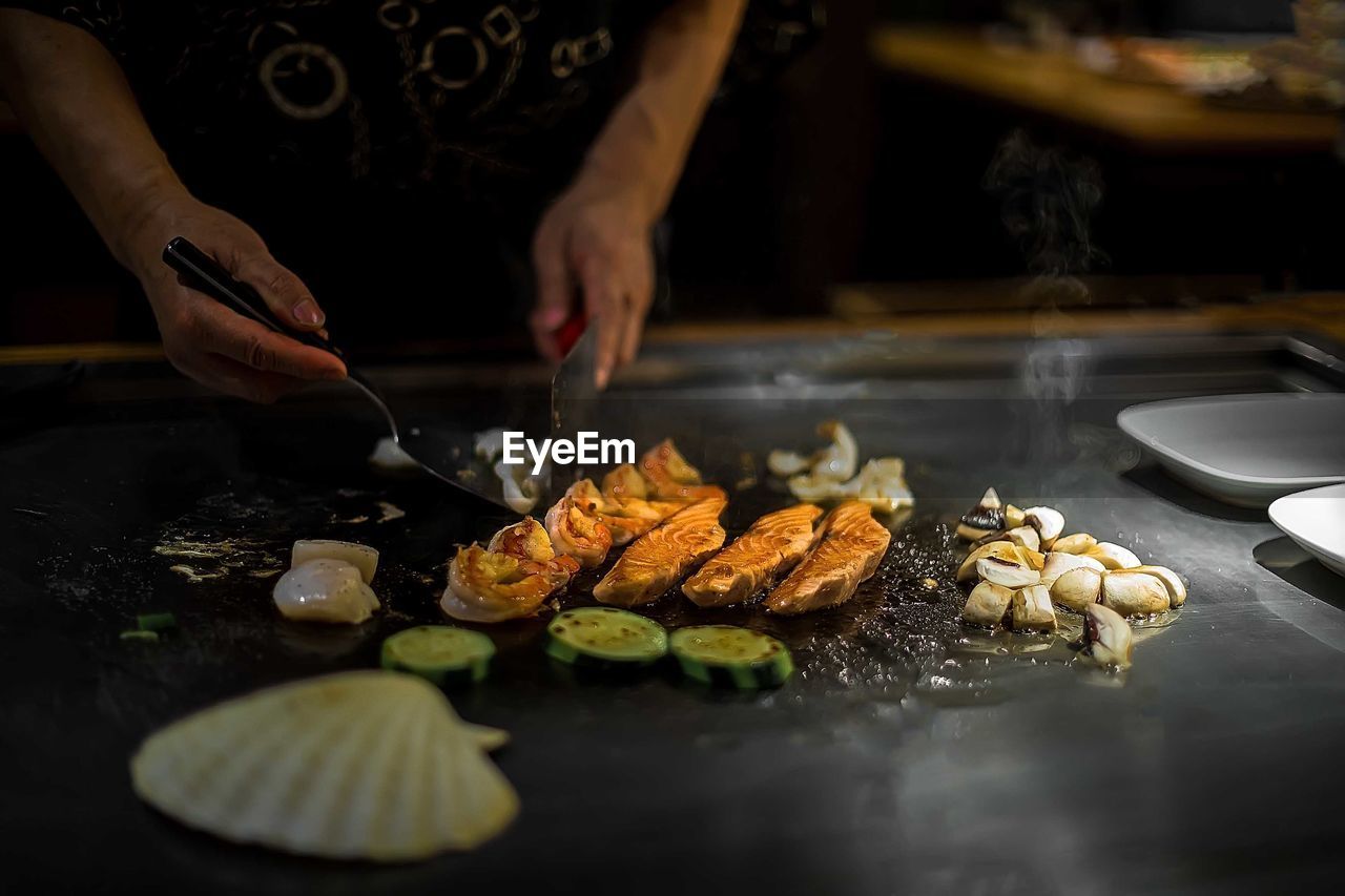 Midsection of person preparing food in kitchen