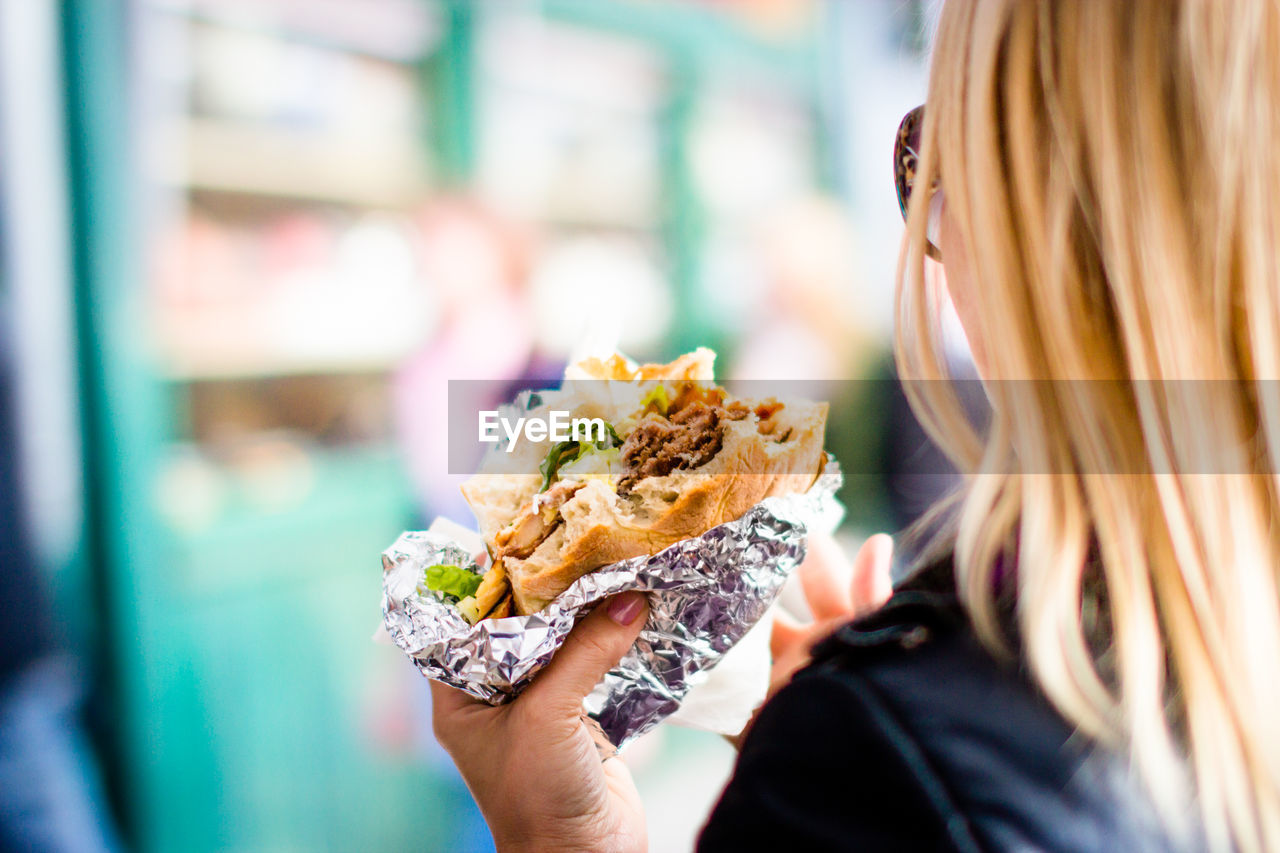 Cropped image of woman holding hamburger