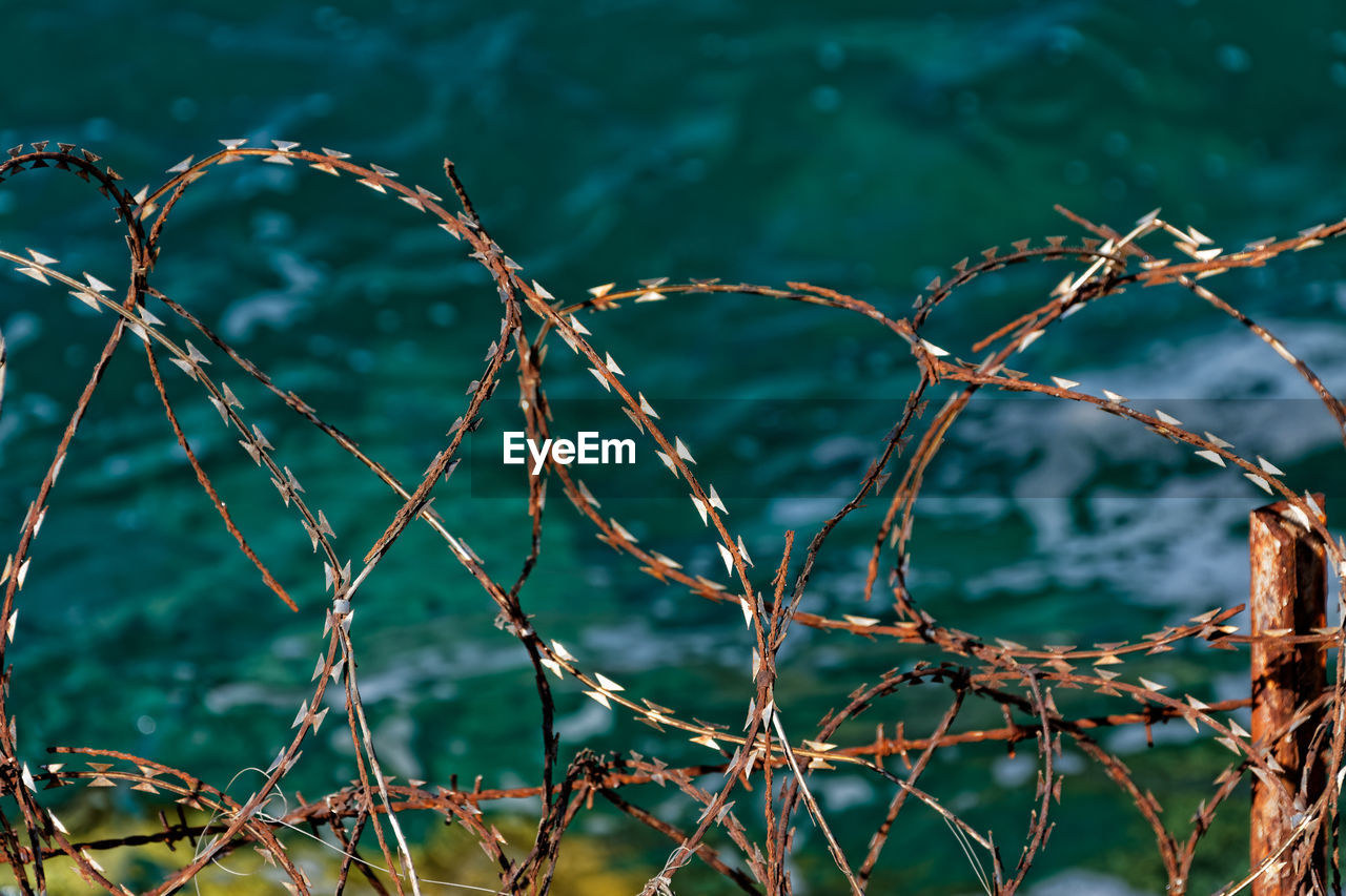 High angle view of barbed wires over sea