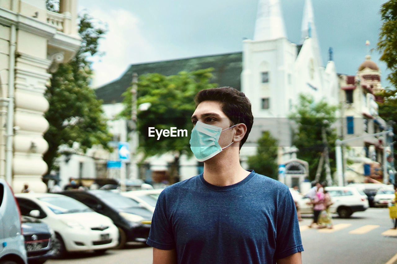 Portrait of young man on street in city