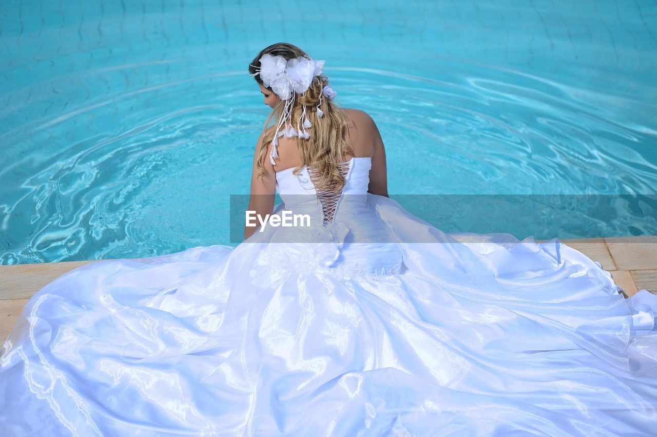 Rear view of woman standing in swimming pool