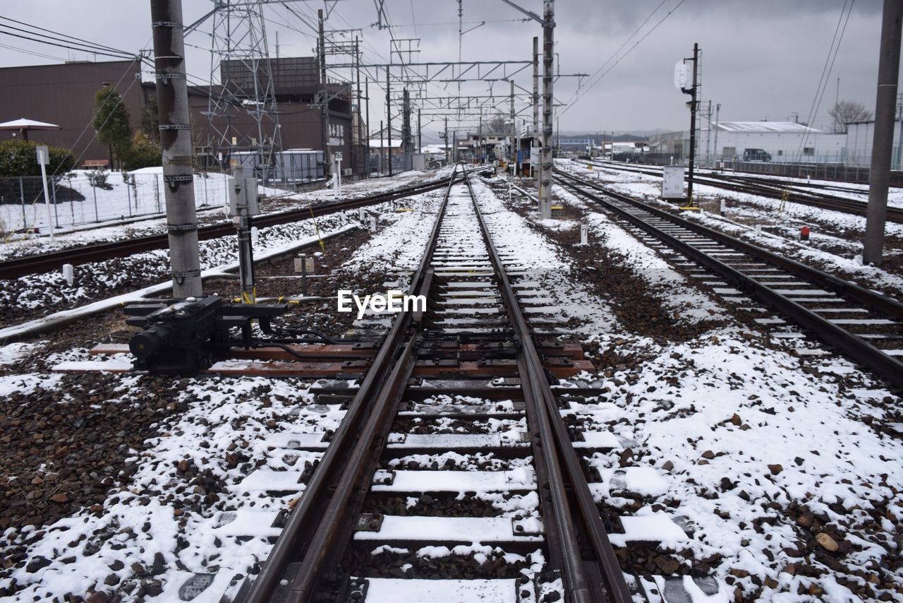 VIEW OF RAILWAY TRACKS IN SNOW COVERED RAILROAD TRACK