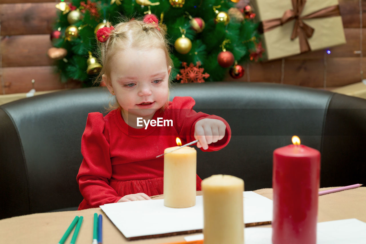 A small child sits at the new year's festive table.