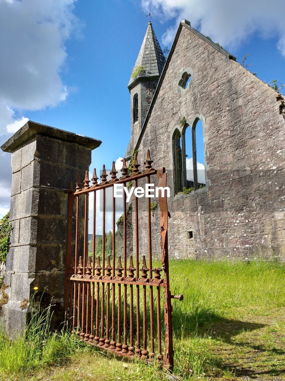 Exterior of old building by church against sky