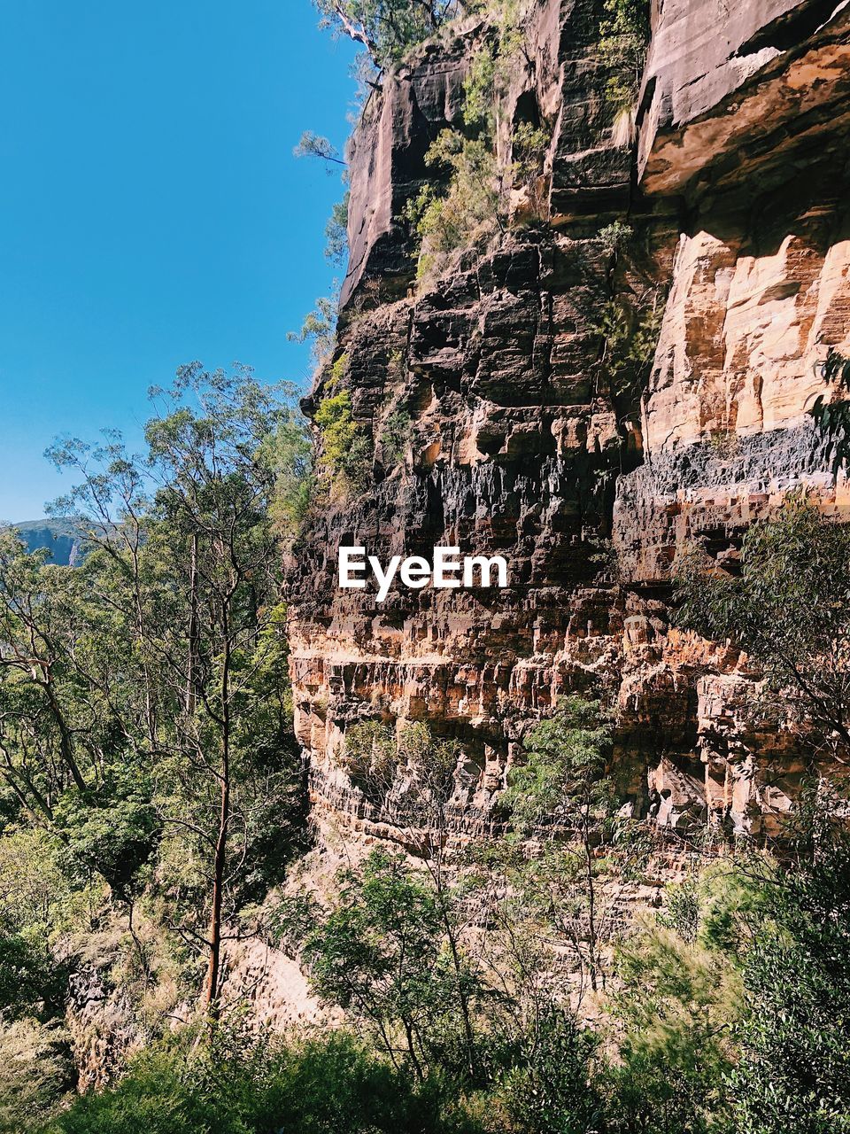 LOW ANGLE VIEW OF ROCK FORMATION ON MOUNTAIN