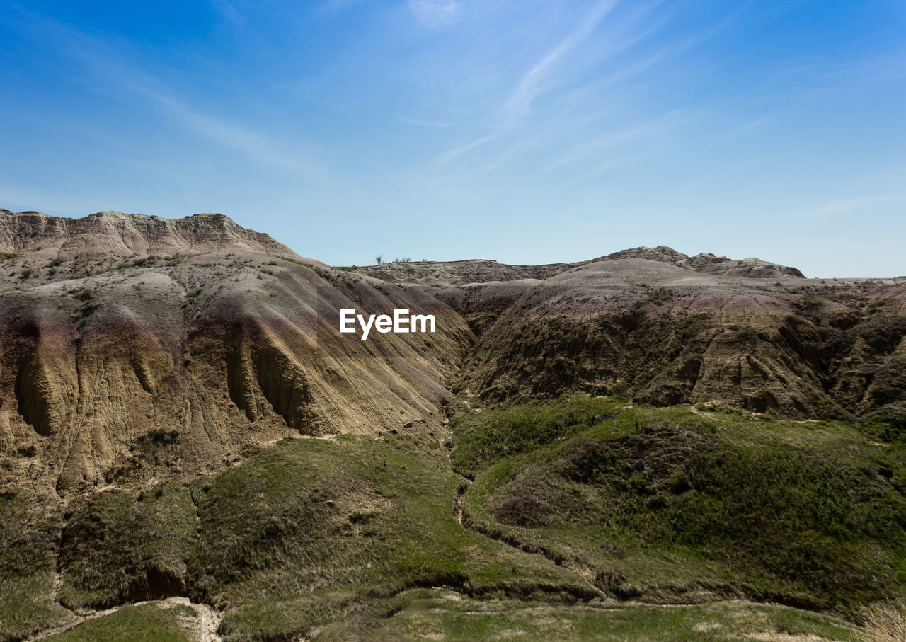 Scenic view of rocky mountains against blue sky