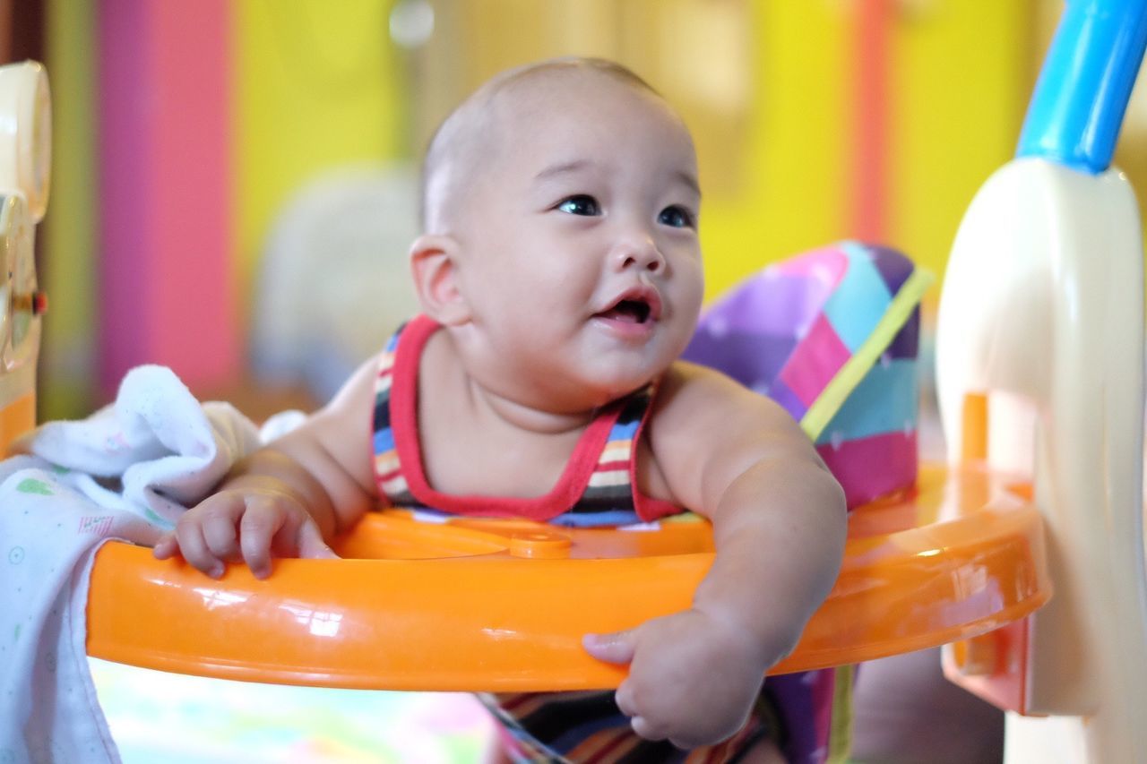 Close-up of cute baby boy on walker at home