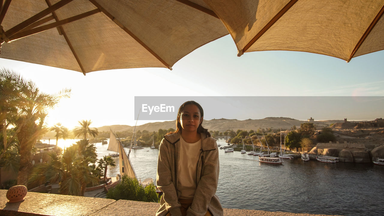 Asian tourist woman at nile river bank sunset in aswan egypt dream exotic trip to africa