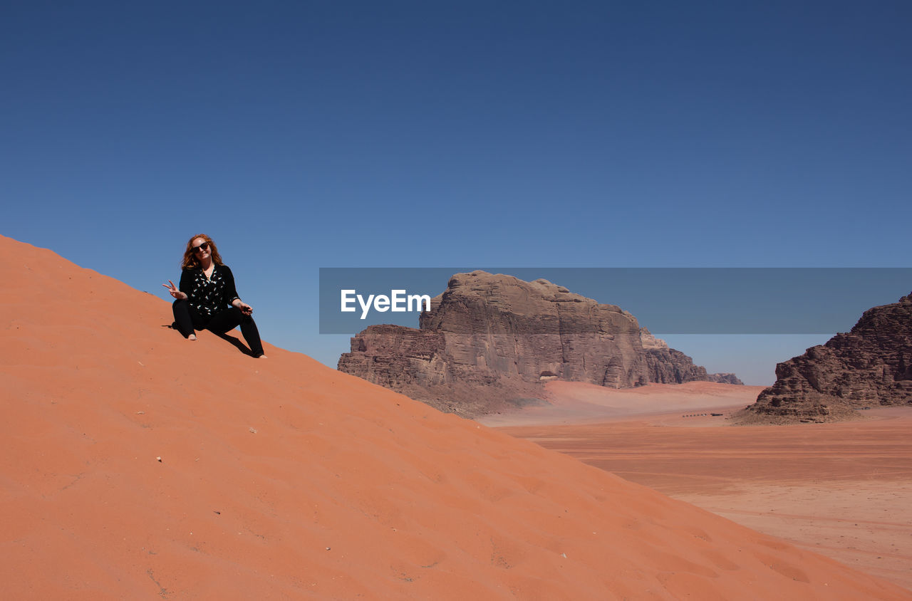 MAN SKIING ON DESERT AGAINST SKY