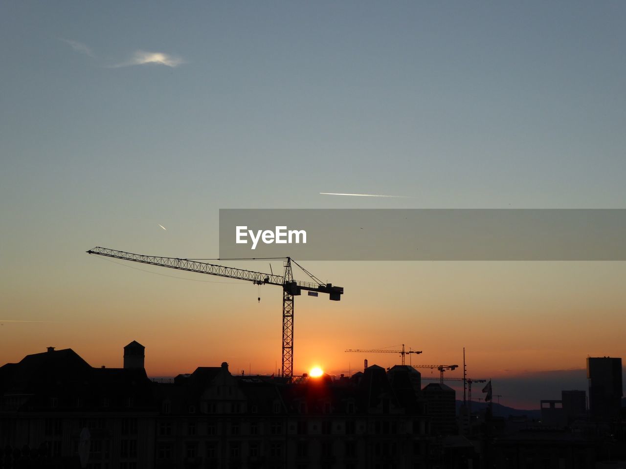 Silhouette crane against sky during sunset