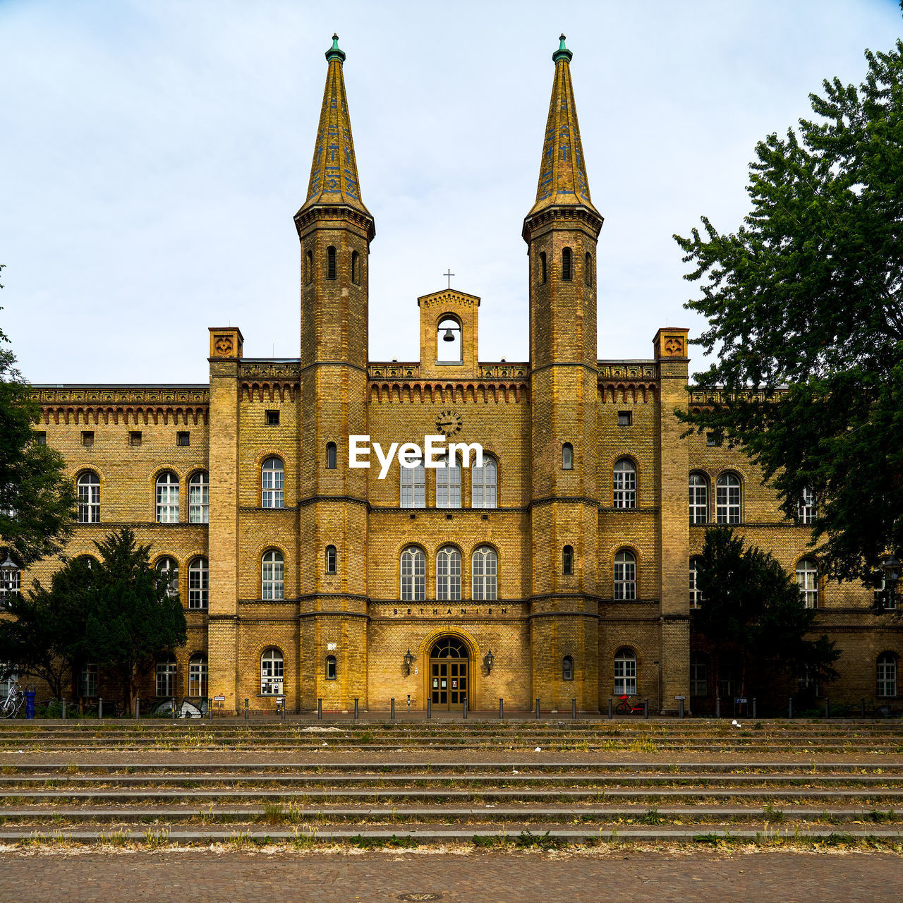 LOW ANGLE VIEW OF BUILDING AND TREES AGAINST SKY