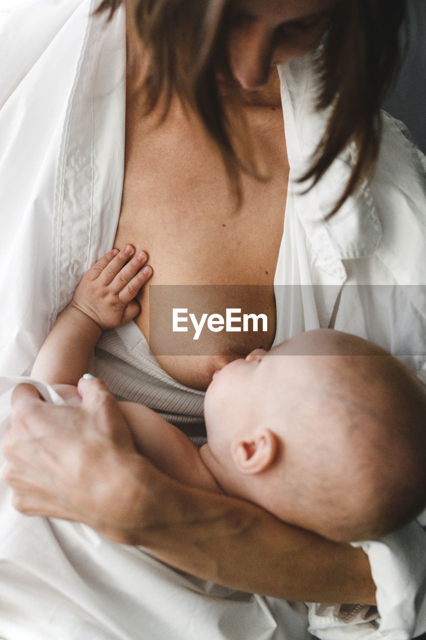 Midsection of woman breast feeding baby girl 