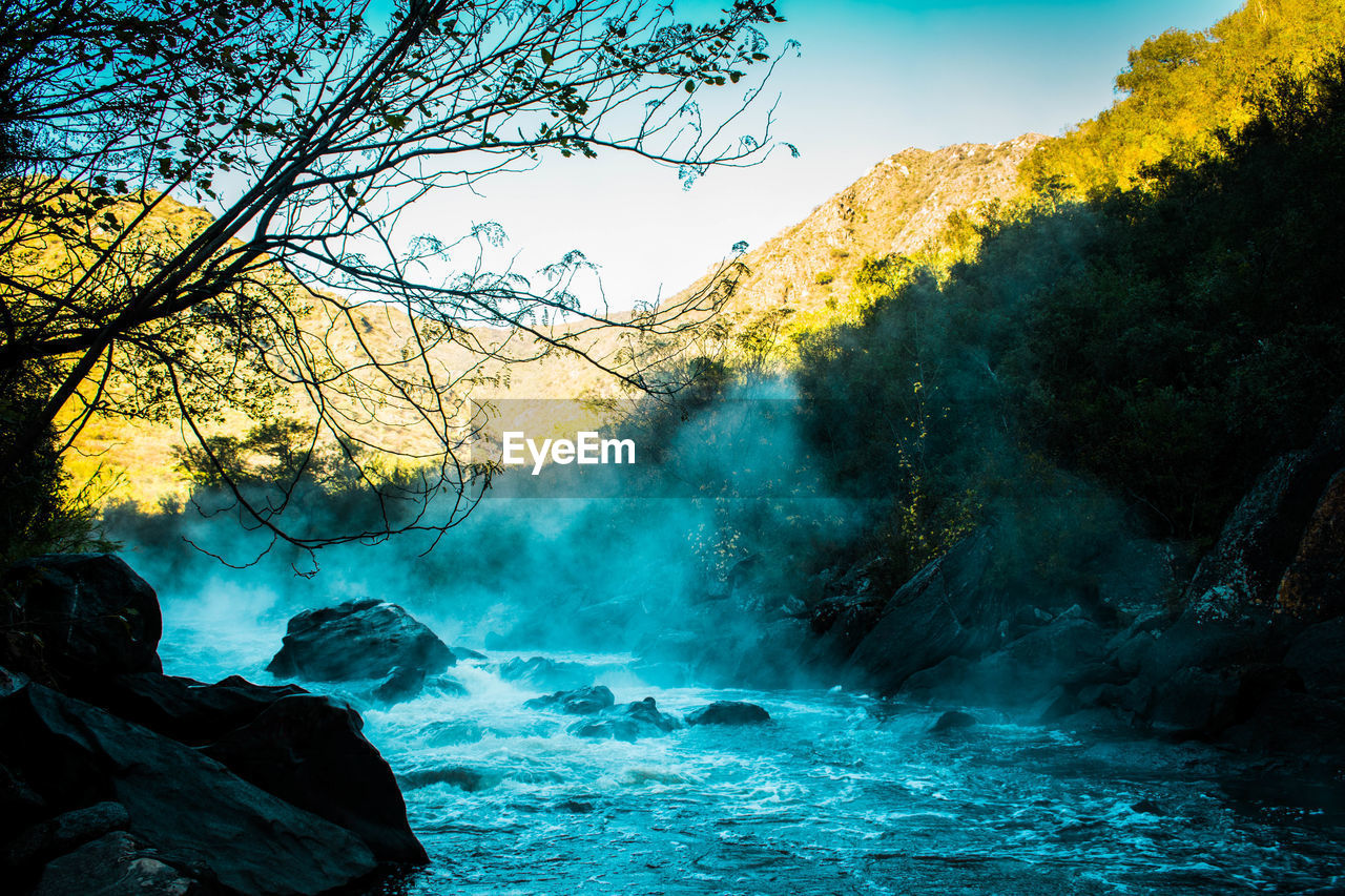 SCENIC VIEW OF WATERFALL AGAINST ROCKS