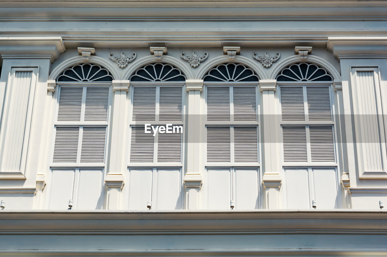 LOW ANGLE VIEW OF BUILDING IN GLASS WINDOW