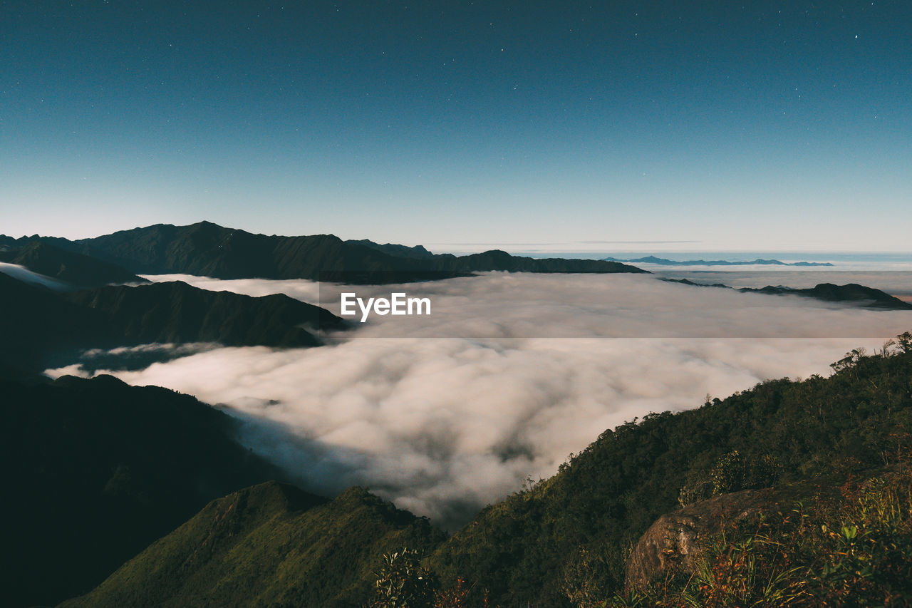 Scenic view of land and mountains against sky