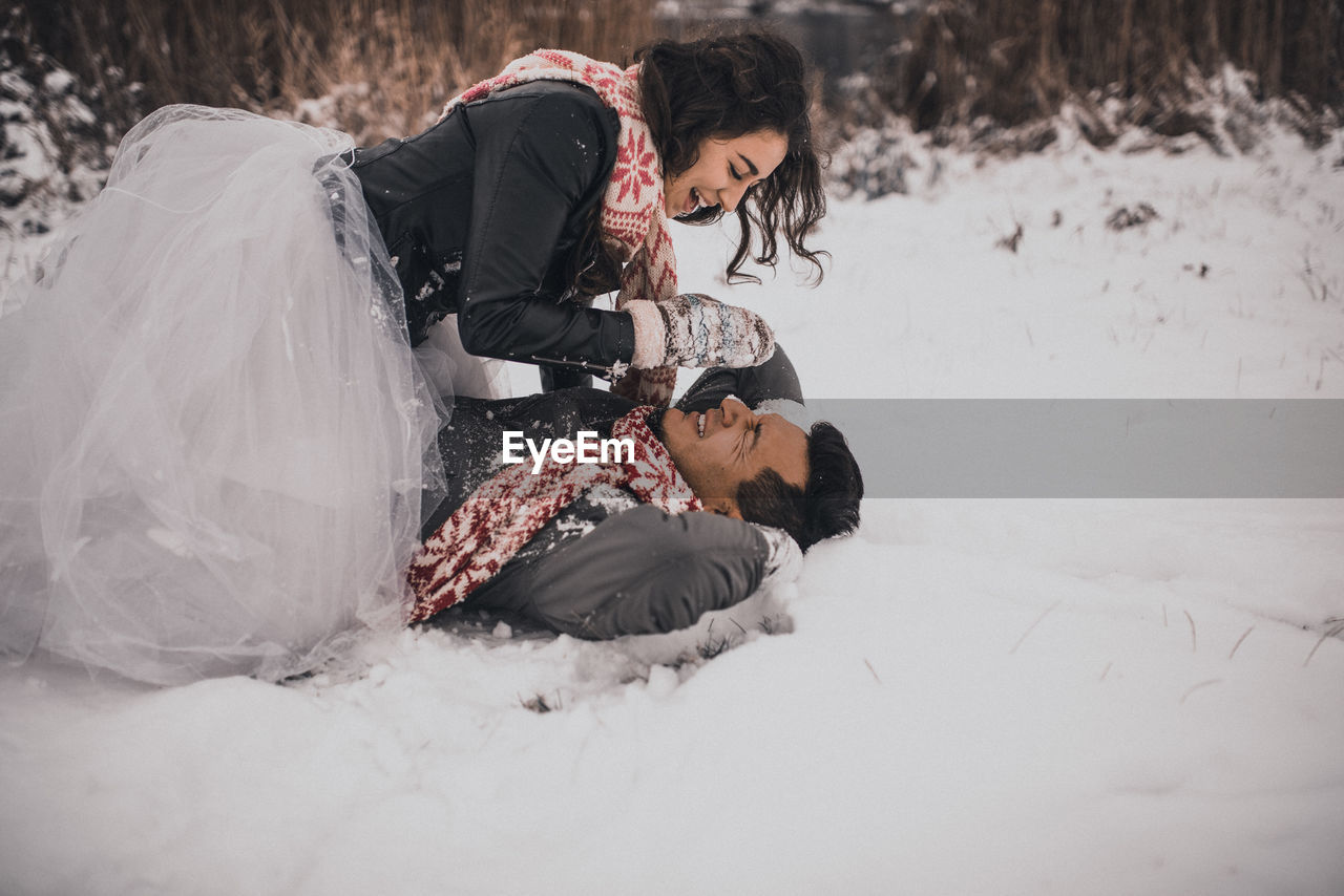 rear view of woman sitting on snow covered field