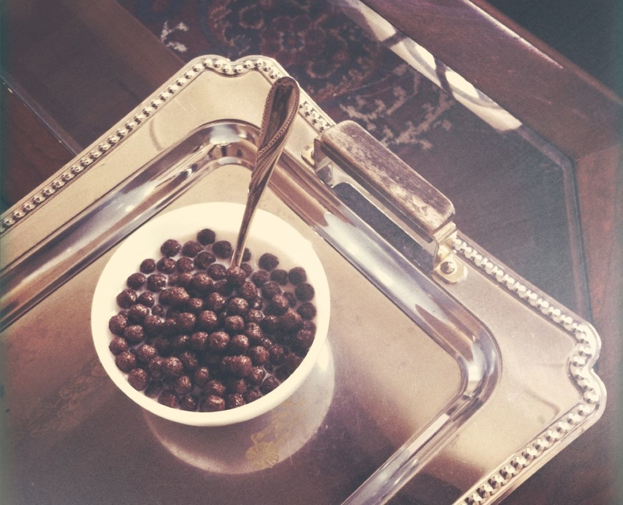 Bowl of chocolate crispies and milk on a silver tray