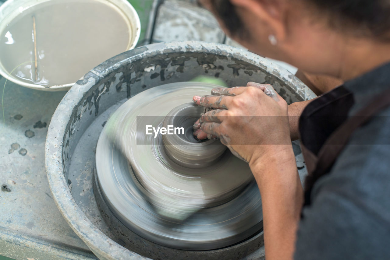 High angle view of woman working on pottery wheel