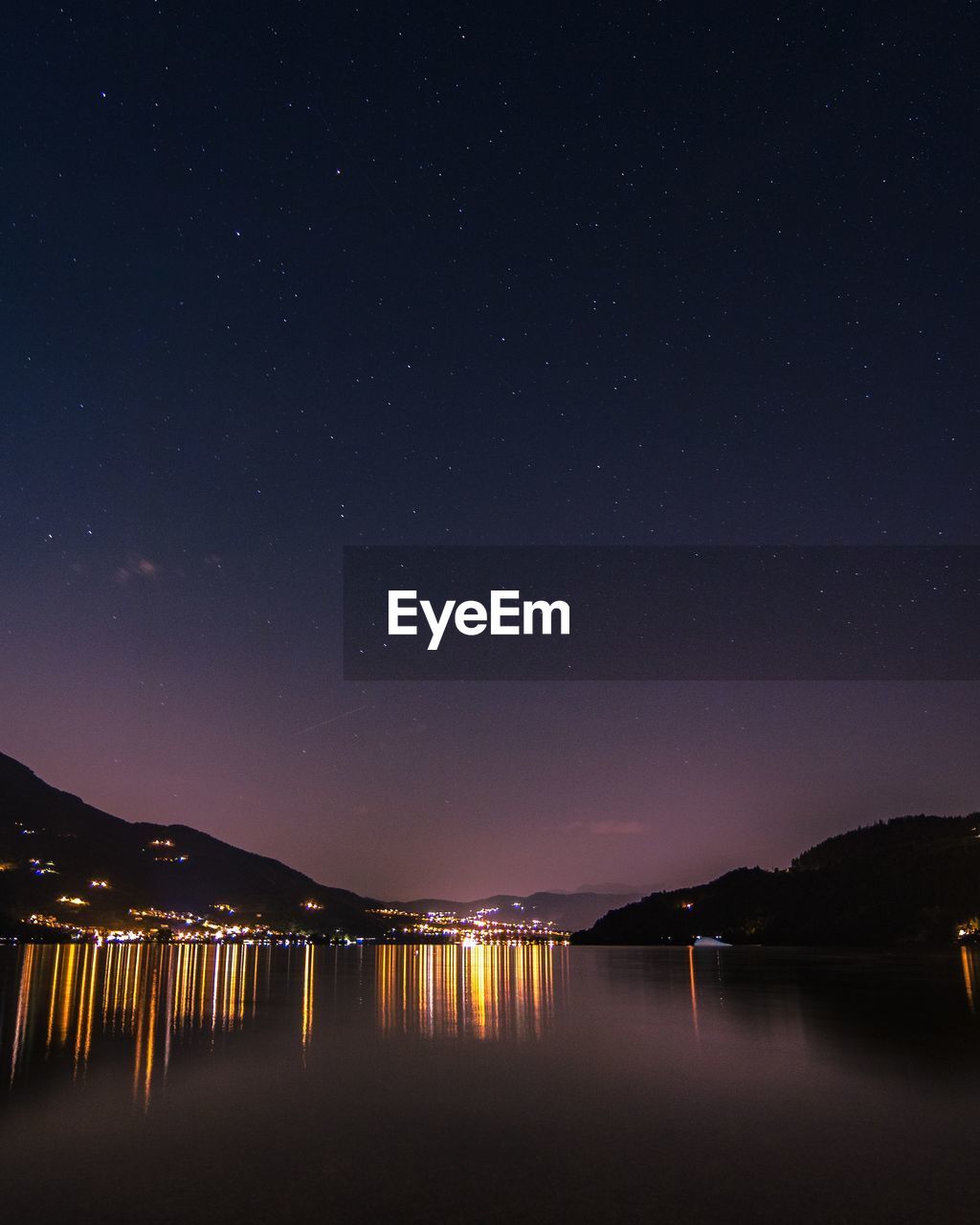 Scenic view of lake against sky at night