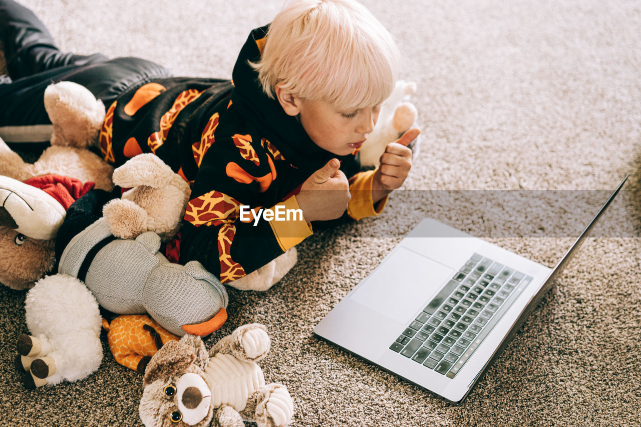 Young boy video conferencing with class on computer