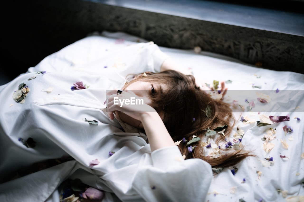 High angle view of woman lying on bed