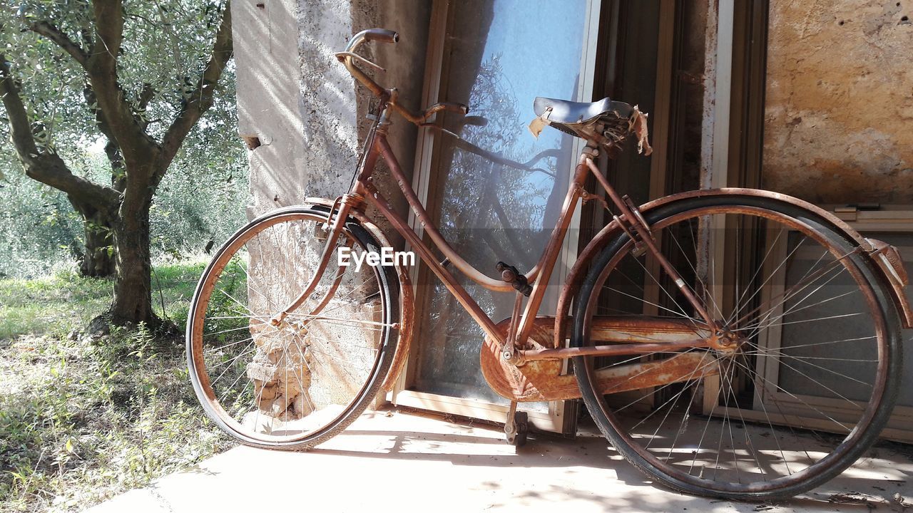 Abandoned bicycle parked by wall