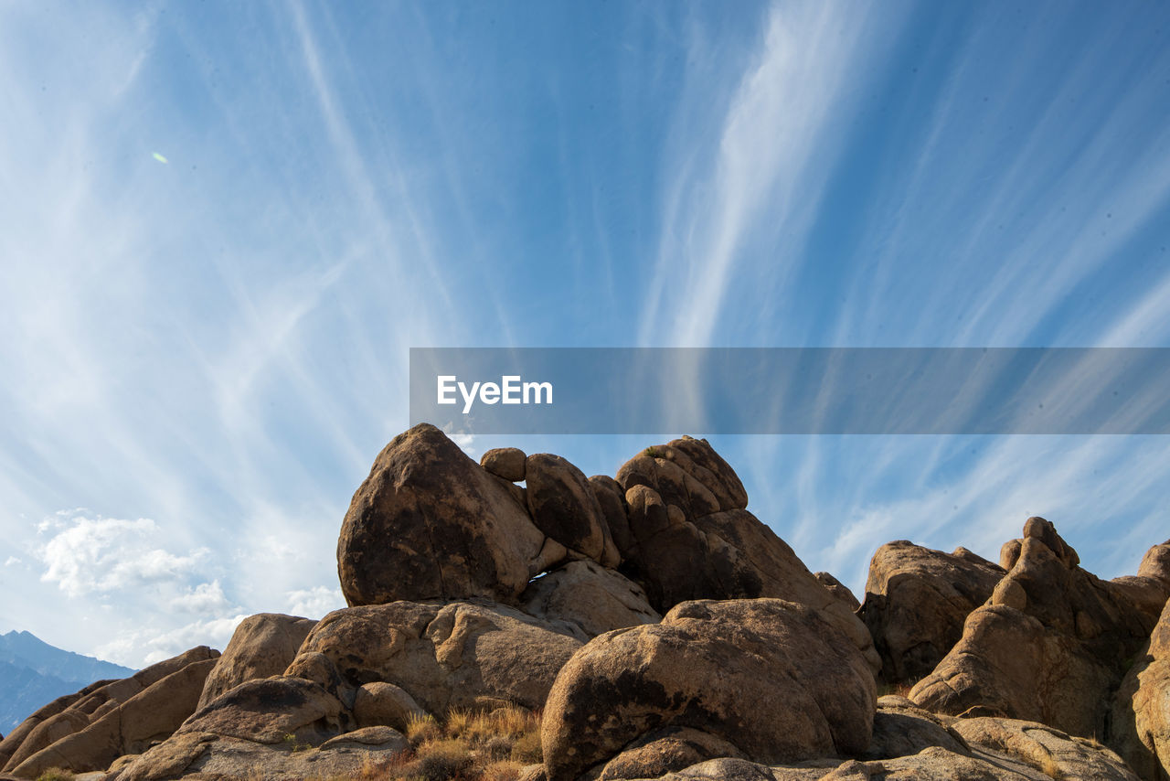 Rock formations against sky with layered clouds