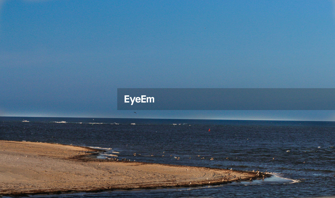 Scenic view of sea against clear blue sky