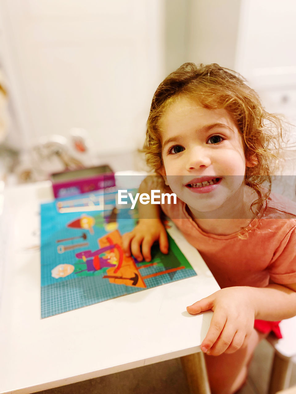 Portrait of cute girl at home playing puzzle 