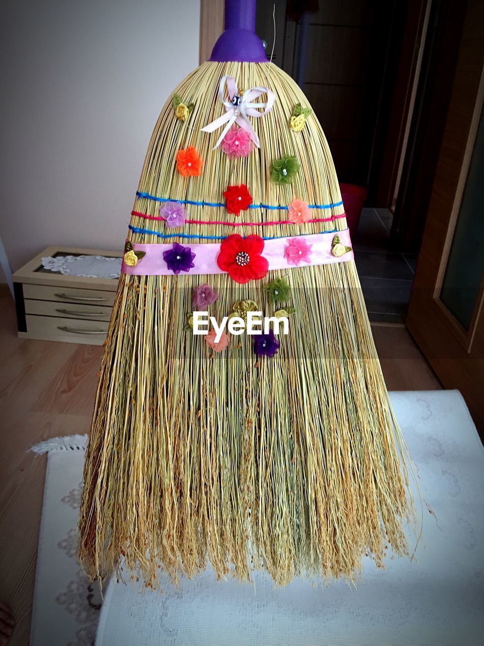 Close-up of decorated broom on table at home