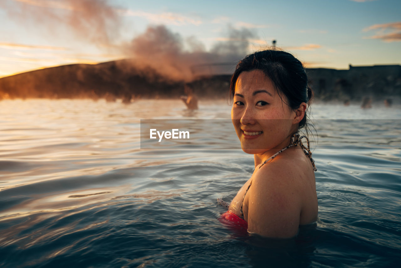 Portrait of young woman swimming in sea