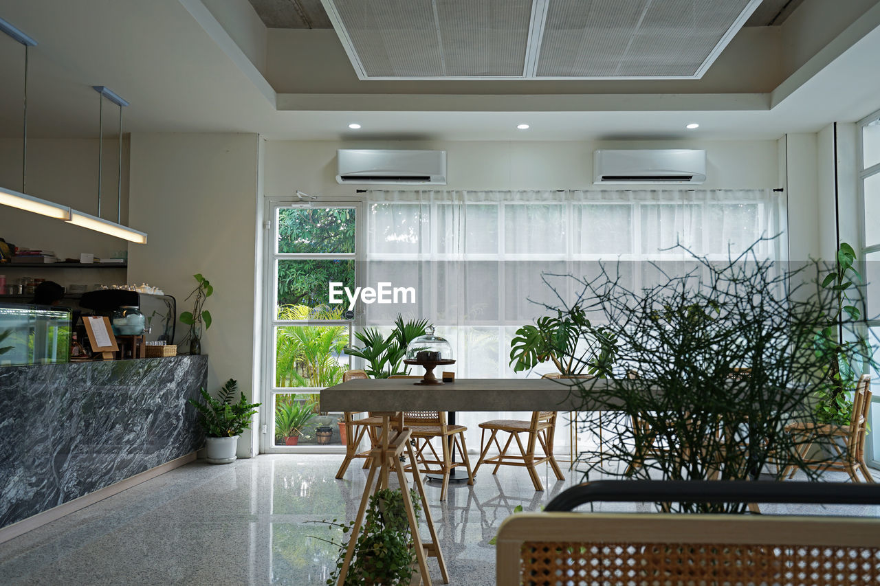 Interior design decoration of cafe and bakery shop decorated with wooden furniture and plant pots