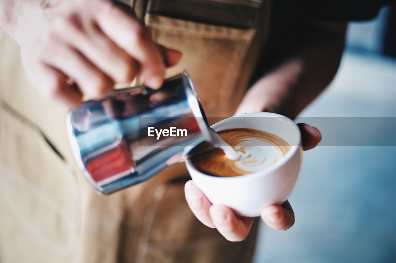 Close-up of hand holding coffee cup