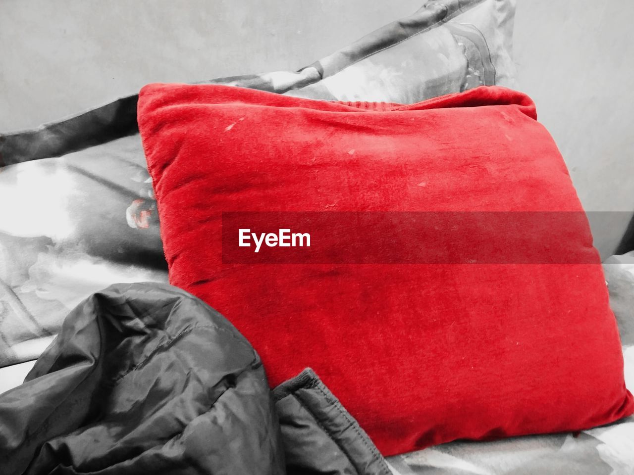 Close-up of red cushion and jacket on sofa