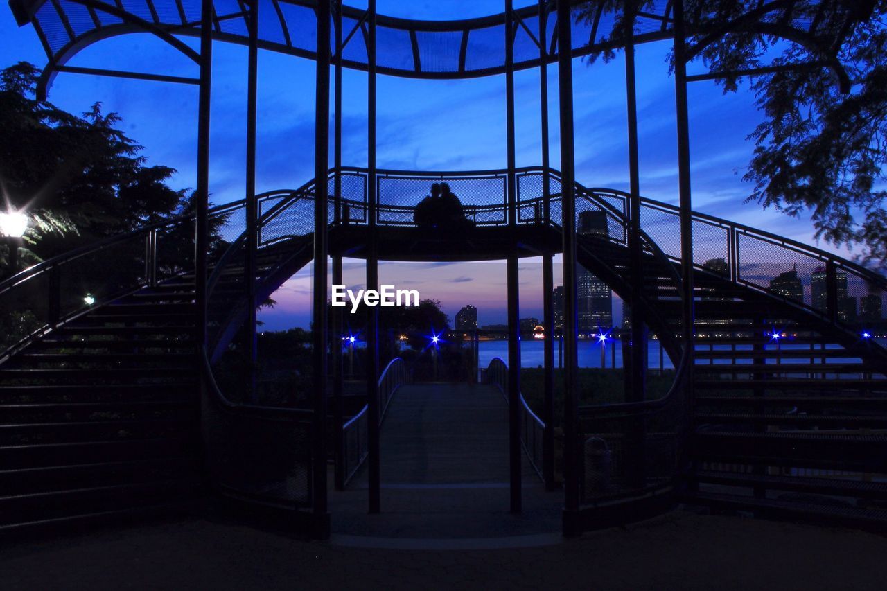 Silhouette couple on footbridge at battery park during dusk