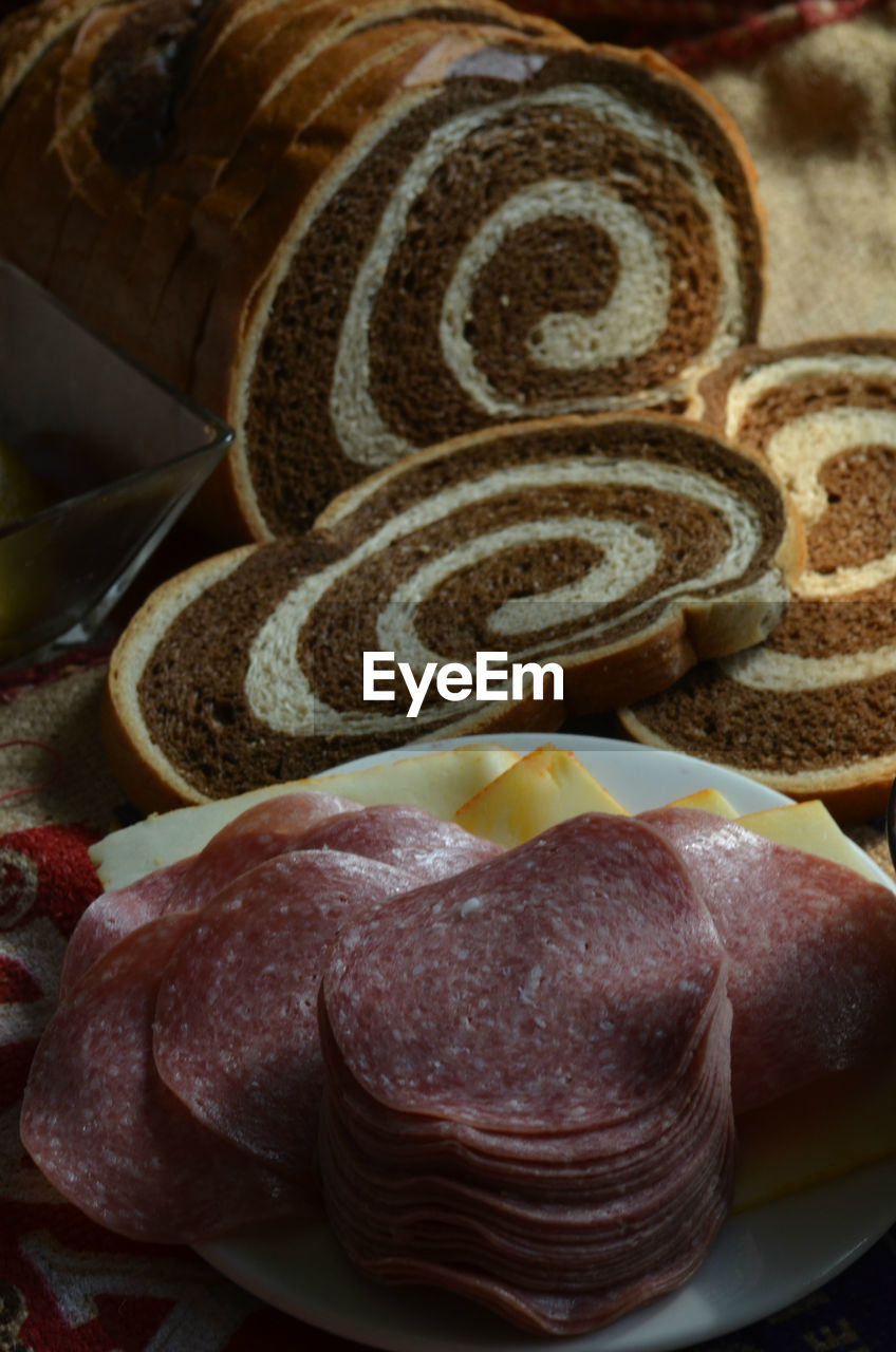 Close-up of marble rye bread by salami on table