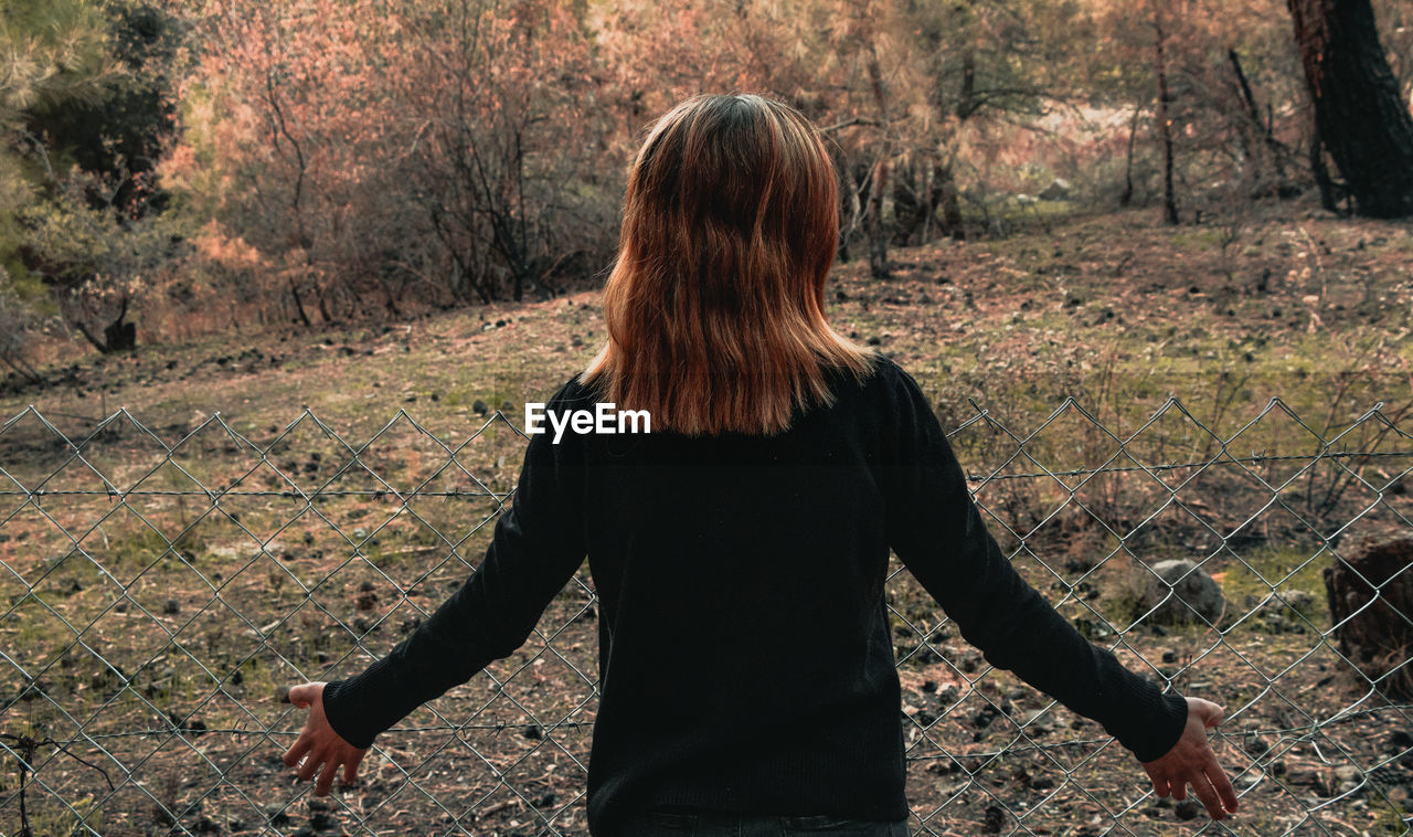 Rear view of woman standing in forest