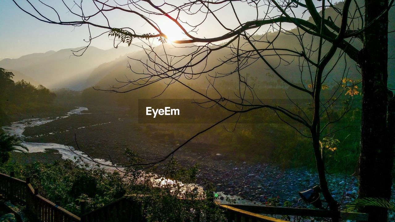 High angle view of river by mountains during sunset