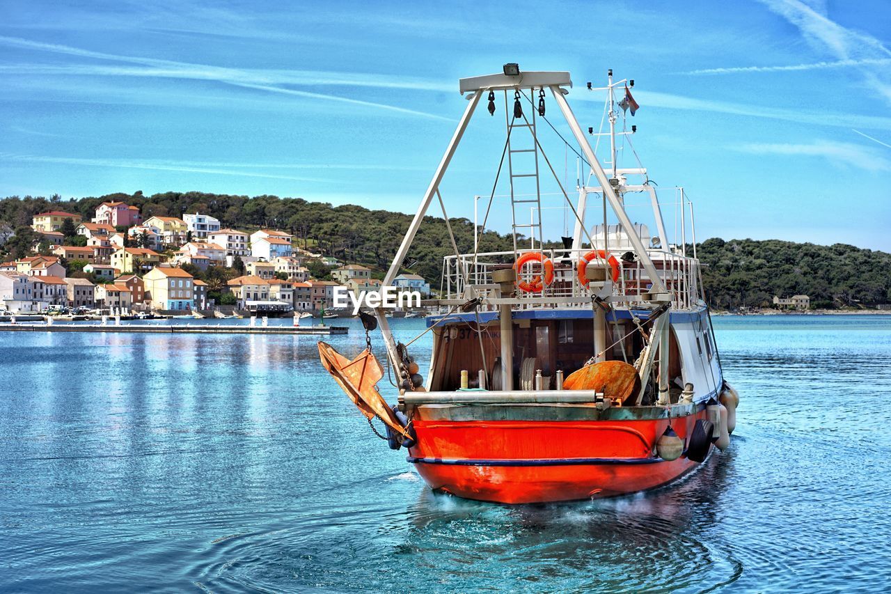 Ship moored at harbor against sky