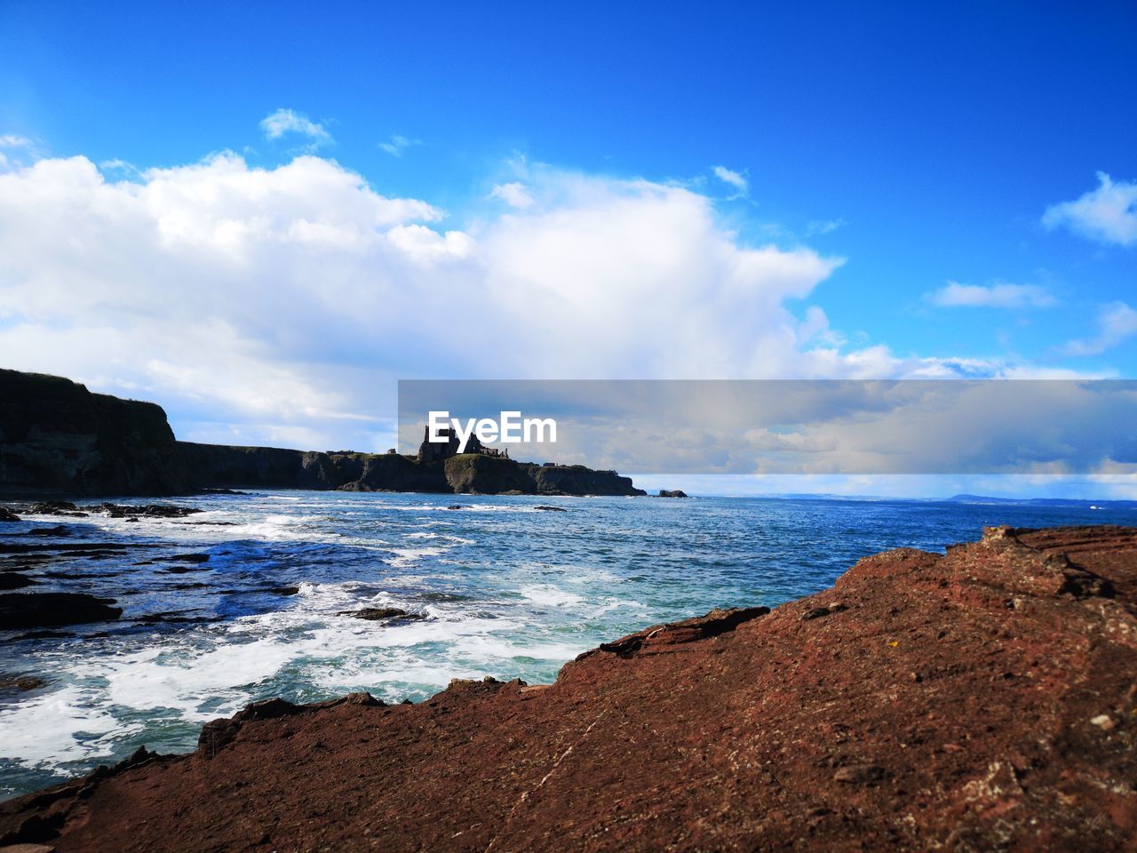 SCENIC VIEW OF ROCKS ON BEACH AGAINST SKY