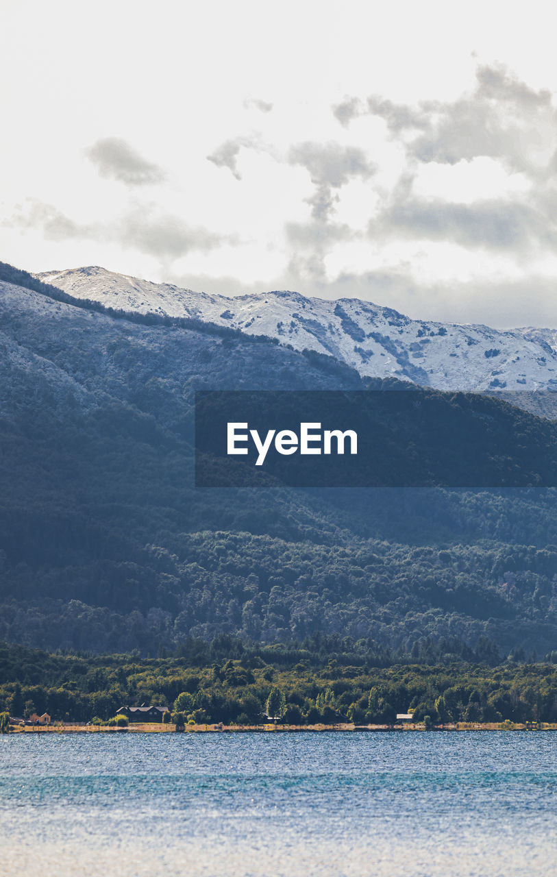 Scenic view of sea by mountains against sky