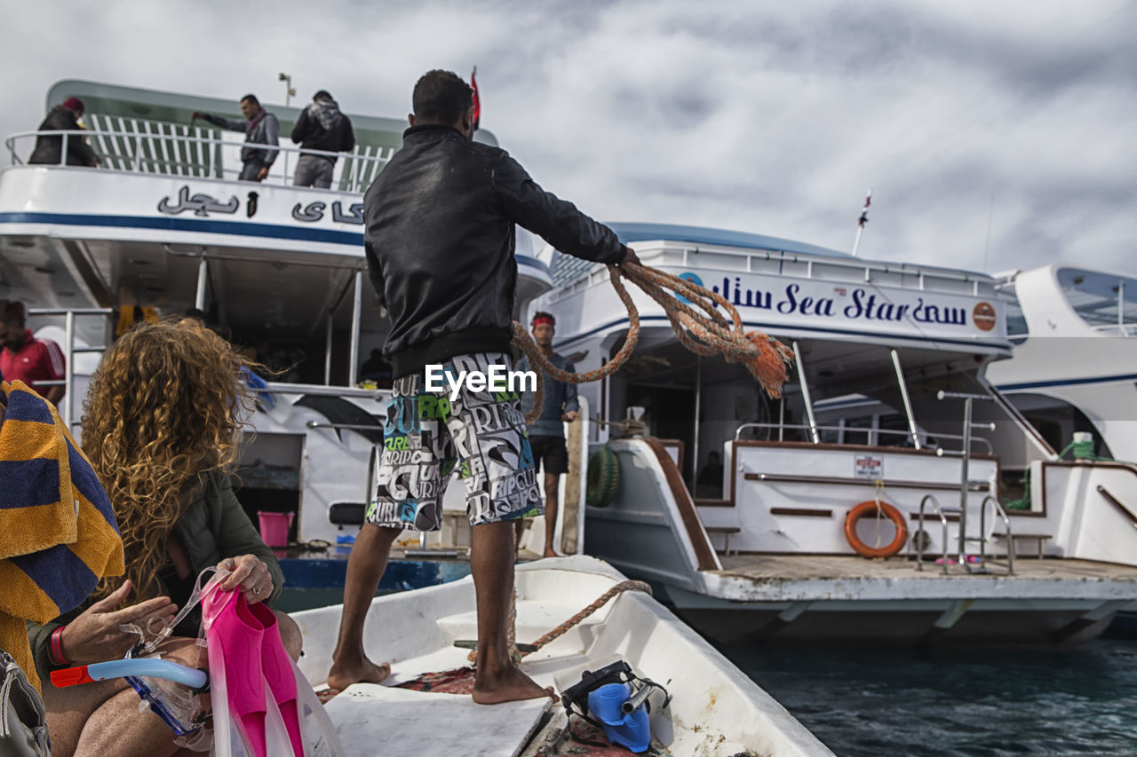 PEOPLE STANDING AT HARBOR