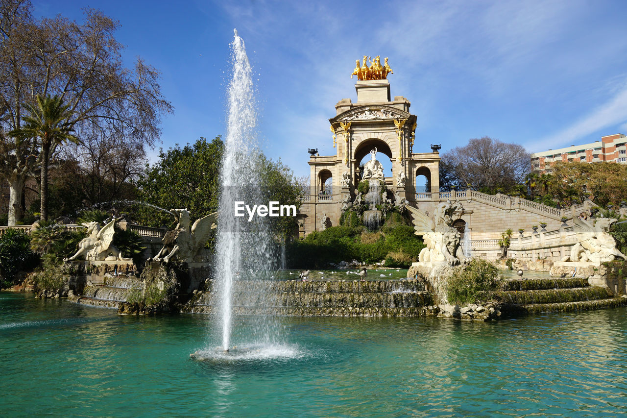 Fountain in pond at parc de la ciutadella against sky