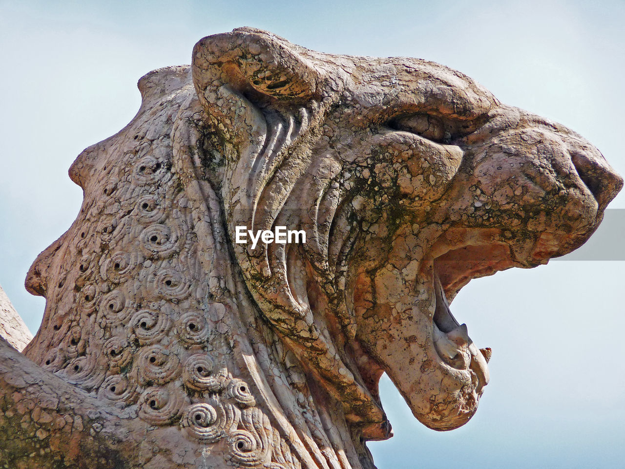 Low angle view of roaring lion statue against clear sky