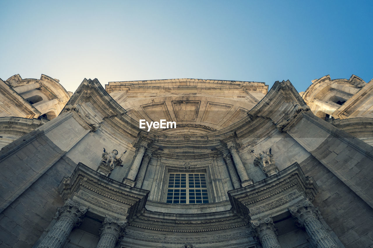 Low angle view of historical building against clear blue sky