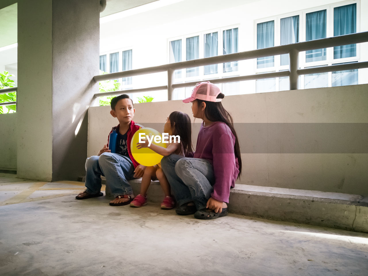 Siblings sitting in parking lot