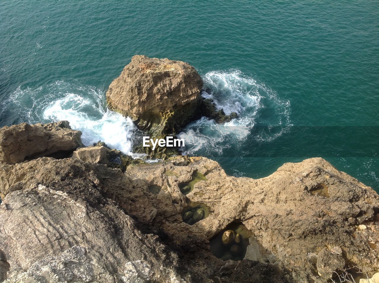 High angle view of rock formations at turquoise sea