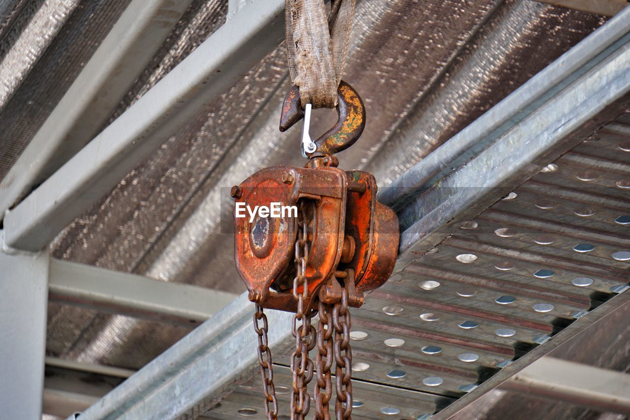 CLOSE-UP OF RUSTY CHAIN HANGING ON CEILING