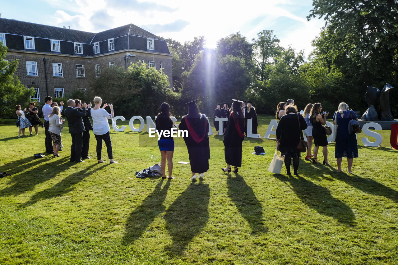 GROUP OF PEOPLE IN FRONT OF PLANTS